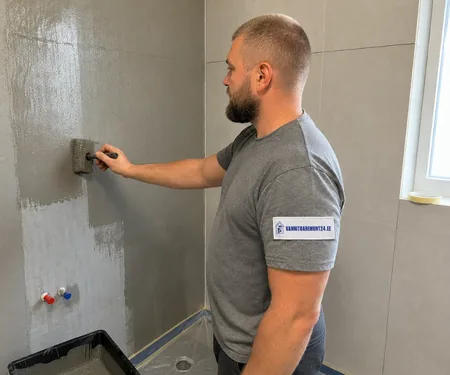 Meister kannab pintsliga dušinurga seinale halli hüdroisolatsiooni, sooja ja külma vee toruotsad on membraani pealekandmise ajal punase ja sinise korgi all, nii ei lähe segisti ühendused vahetusse.