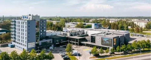 Vannitoa remont Viimsis, suure välisekraaniga kaubanduskeskuse klaasfassaad ja selle kõrval kõrge valge torn päikesepaistel, Viimsi eramu kliendile saadetakse enne remondi algust nimekiri asjadest, mis tuleb vannitoast ja koridorist eemaldada.