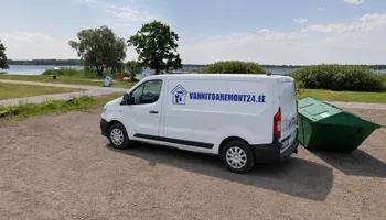 Maardu järve kaldal kruusaplatsil seisab rohelise prügikonteineri kõrval valge kaubik mutrivõtme ja värvirulliga majalogoga, Kallavere elamupiirkonna keskel asub Maardu Peaingel Miikaeli kirik.